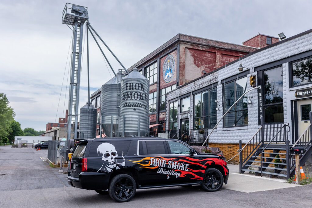 A car parked outside of a brewery with the Iron Smoke logo